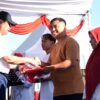 Gubernur Gorontalo Gusnar Ismail (kiri) menyerahkan bendera Merah Putih kepada warga pada pencanangan HUT ke-81 RI di destinasi wisata Danau Perintis, Kabupaten Bone Bolango, Minggu (2/8/2026). (Foto : mcgorontaloprov/Haris)